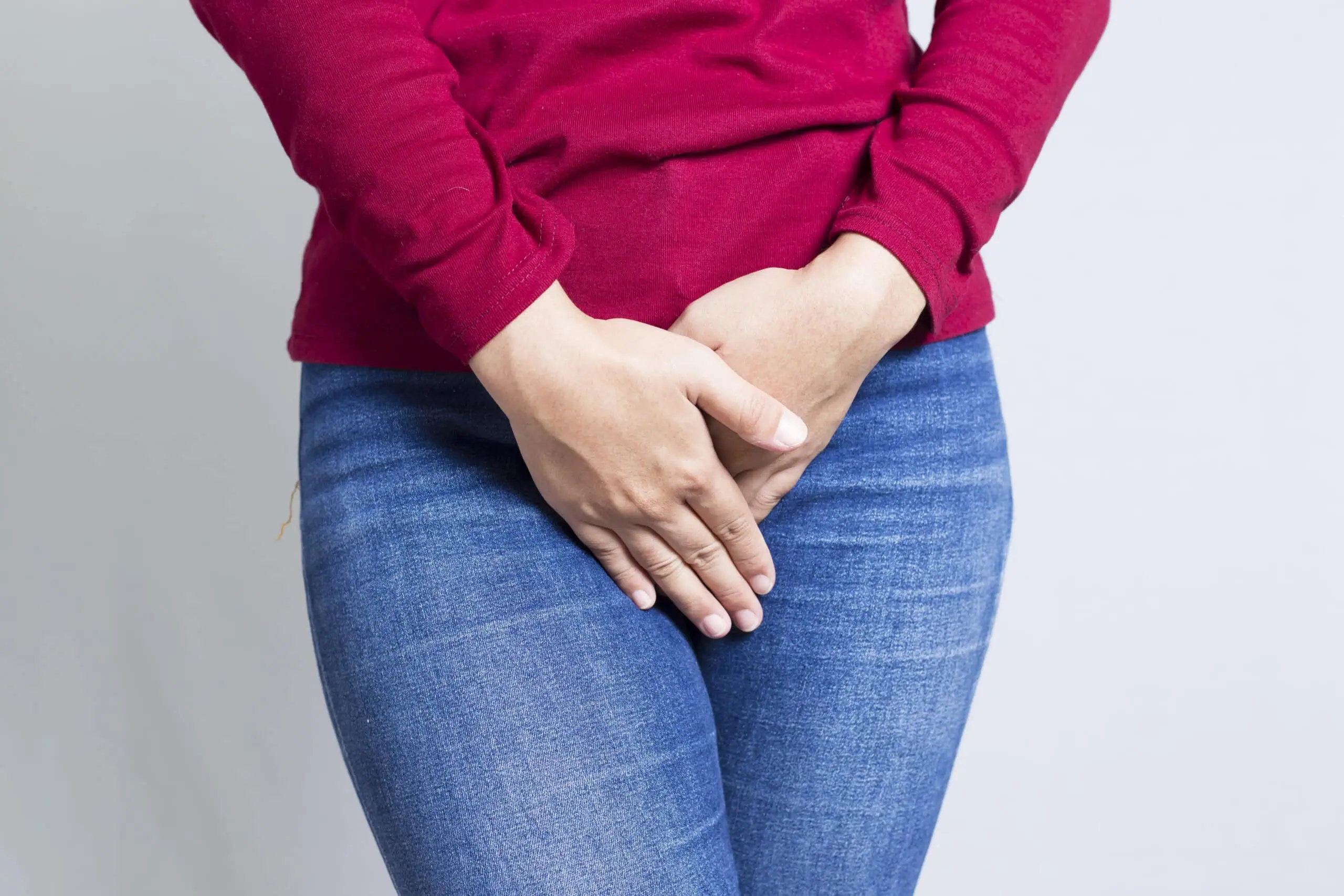 Woman,with,hands,holding,her,crotch,isolated,in,a,white